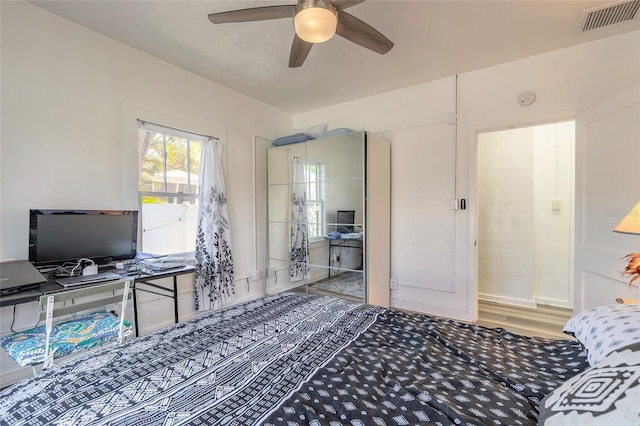 bedroom with visible vents, a ceiling fan, and wood finished floors