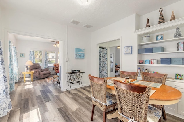 dining room with baseboards, wood finished floors, and a textured ceiling