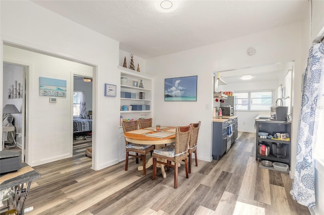 dining space with light wood-style flooring and baseboards
