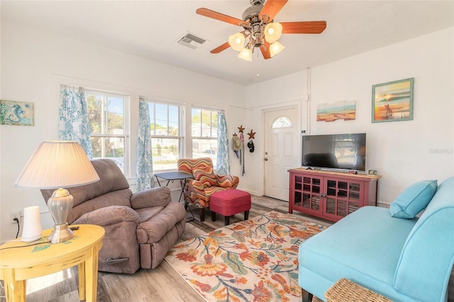 living area featuring visible vents, wood finished floors, and ceiling fan