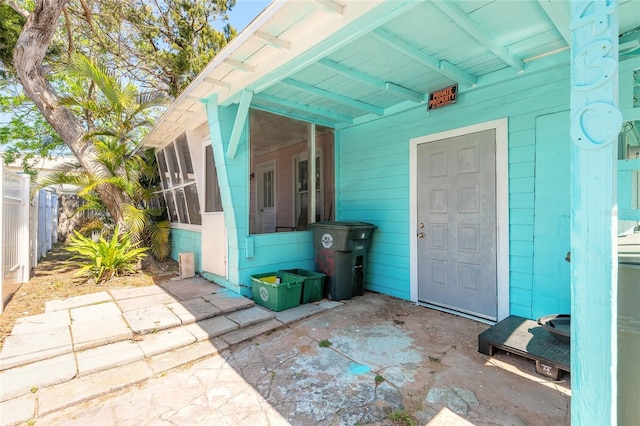 view of patio / terrace featuring a sunroom and fence