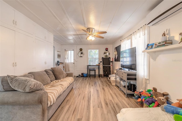 living area with light wood finished floors, a decorative wall, and a ceiling fan