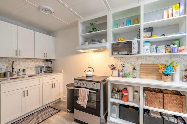 kitchen featuring a sink, open shelves, light wood finished floors, white cabinetry, and electric range