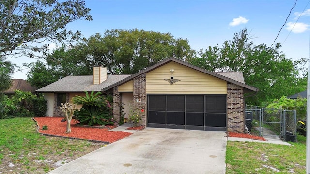 view of front of home with brick siding, fence, concrete driveway, an attached garage, and a gate