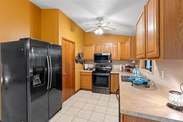 kitchen featuring a ceiling fan, a sink, appliances with stainless steel finishes, light tile patterned flooring, and light countertops