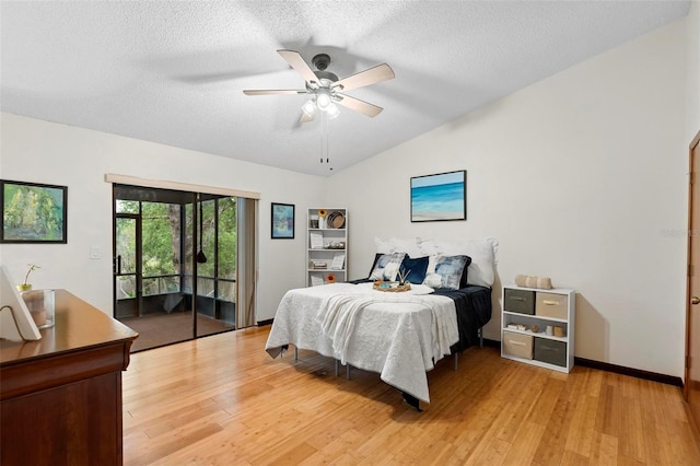 bedroom featuring light wood-style flooring, a textured ceiling, a ceiling fan, and vaulted ceiling