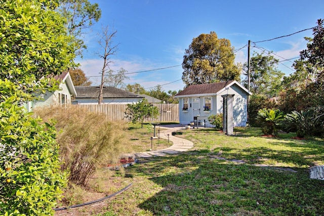 view of yard featuring an outdoor structure and fence