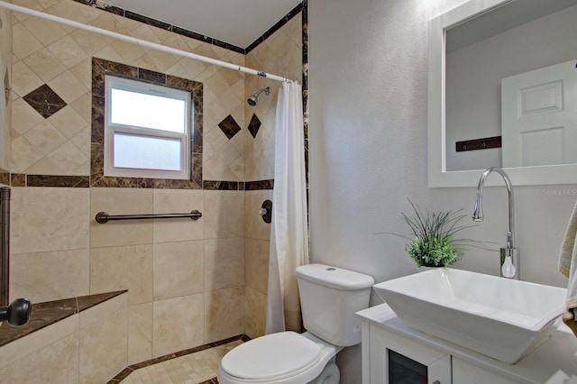full bath featuring a textured wall, toilet, vanity, and a tile shower