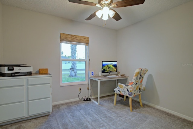 home office featuring light colored carpet, a textured ceiling, baseboards, and ceiling fan