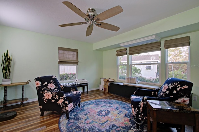 sitting room featuring wood finished floors, baseboards, and ceiling fan