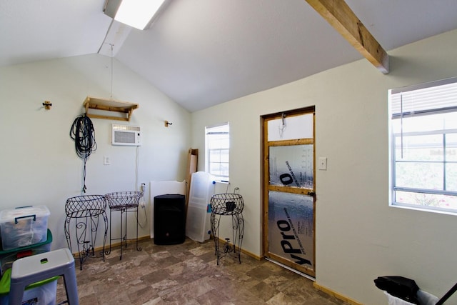 interior space featuring baseboards, vaulted ceiling with beams, and a wall unit AC