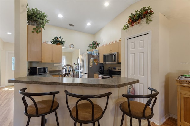 723 Pelican Ct, Kissimmee, FL 34759 - kitchen featuring visible vents, dark countertops, appliances with stainless steel finishes, and light brown cabinets