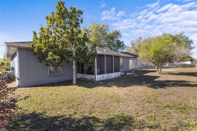 723 Pelican Ct, Kissimmee, FL 34759 - back of house with stucco siding, a sunroom, a yard, and fence