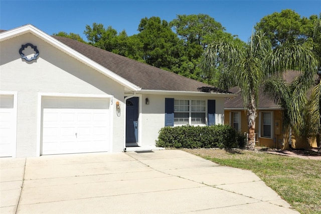 ranch-style house featuring an attached garage, stucco siding, and concrete driveway