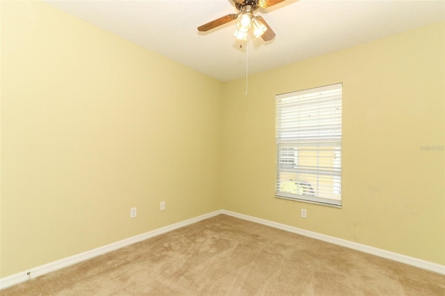 unfurnished room featuring baseboards, ceiling fan, and light carpet
