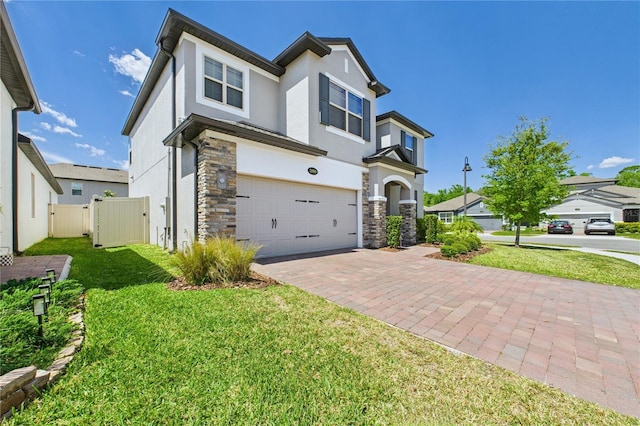 2090 Prairie Sage Ln, Longwood, FL 32750 - view of front of home with stone siding, stucco siding, fence, decorative driveway, and a garage