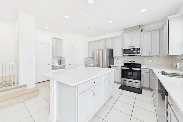 2090 Prairie Sage Ln, Longwood, FL 32750 - kitchen with light countertops, a kitchen island, appliances with stainless steel finishes, a sink, and light tile patterned floors