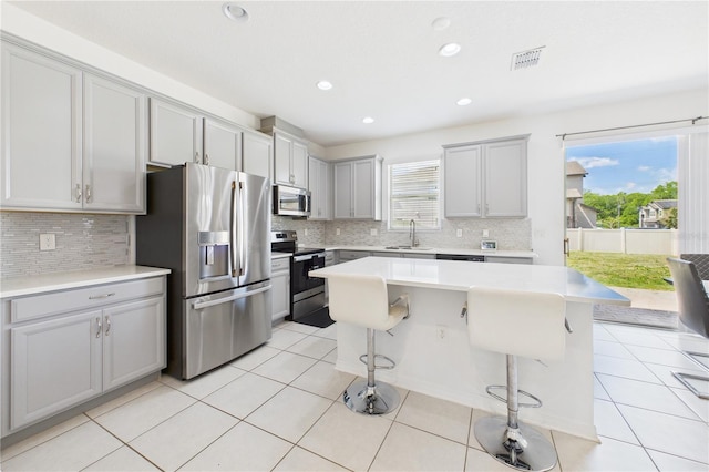 2090 Prairie Sage Ln, Longwood, FL 32750 - kitchen featuring light tile patterned floors, appliances with stainless steel finishes, a breakfast bar, and visible vents