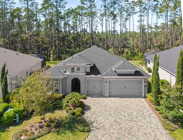 354 Stirling Bridge Dr, Ormond Beach, FL 32174 - view of front of property featuring an attached garage, stucco siding, driveway, and a shingled roof
