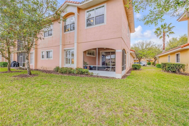 3145 Connemara Dr, Ormond Beach, FL 32174 - back of house featuring a yard, stucco siding, and a tile roof