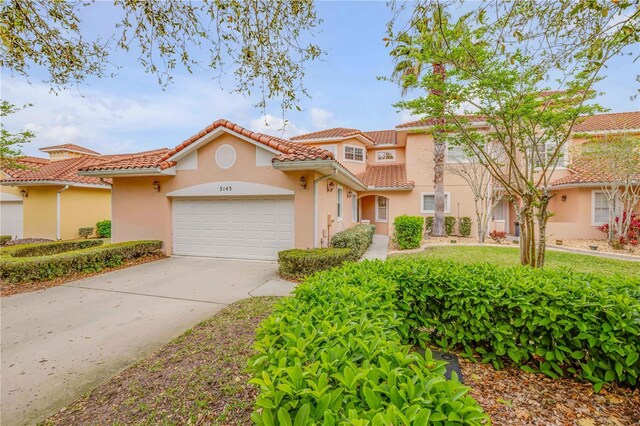 3145 Connemara Dr, Ormond Beach, FL 32174 - mediterranean / spanish-style house featuring stucco siding, an attached garage, driveway, and a tile roof