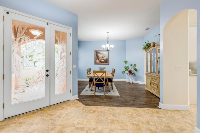 3145 Connemara Dr, Ormond Beach, FL 32174 - entrance foyer featuring french doors, a chandelier, arched walkways, and baseboards