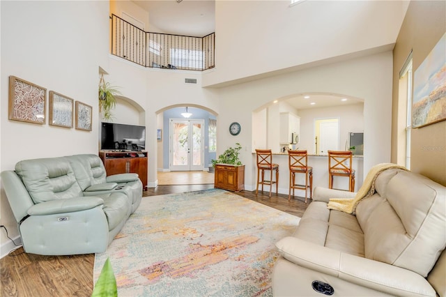 3145 Connemara Dr, Ormond Beach, FL 32174 - living room featuring arched walkways, wood finished floors, and a towering ceiling