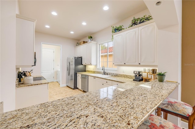 3145 Connemara Dr, Ormond Beach, FL 32174 - kitchen featuring appliances with stainless steel finishes, a sink, recessed lighting, light stone counters, and white cabinets