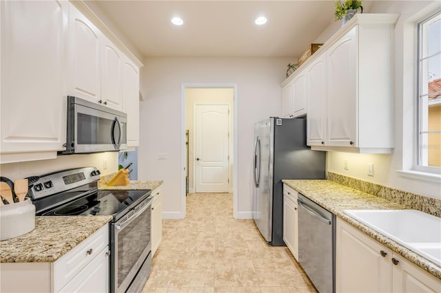 3145 Connemara Dr, Ormond Beach, FL 32174 - kitchen with appliances with stainless steel finishes, recessed lighting, white cabinetry, baseboards, and a sink