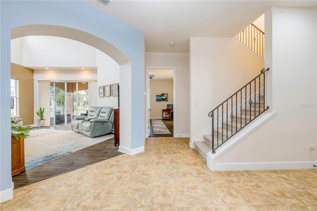 3145 Connemara Dr, Ormond Beach, FL 32174 - foyer entrance with arched walkways, stairway, and baseboards