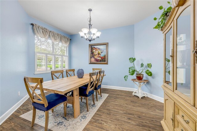 3145 Connemara Dr, Ormond Beach, FL 32174 - dining area with a chandelier, baseboards, and dark wood-type flooring