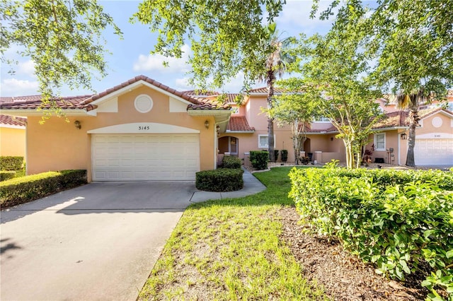 3145 Connemara Dr, Ormond Beach, FL 32174 - mediterranean / spanish-style house with stucco siding, a garage, a tiled roof, and concrete driveway