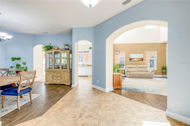 3145 Connemara Dr, Ormond Beach, FL 32174 - dining area with arched walkways, a chandelier, and light tile patterned flooring