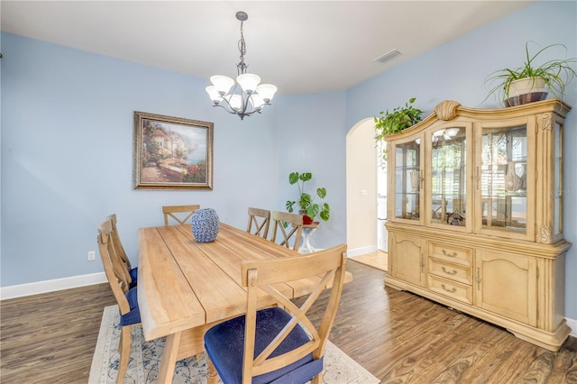 3145 Connemara Dr, Ormond Beach, FL 32174 - dining area with arched walkways, a chandelier, and wood finished floors