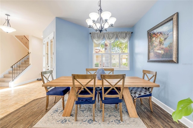 3145 Connemara Dr, Ormond Beach, FL 32174 - dining room featuring stairway, wood finished floors, and a chandelier
