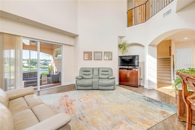 3145 Connemara Dr, Ormond Beach, FL 32174 - living room featuring a towering ceiling, wood finished floors, arched walkways, and stairs