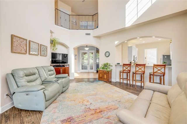 3145 Connemara Dr, Ormond Beach, FL 32174 - living area with arched walkways, wood finished floors, french doors, and a high ceiling