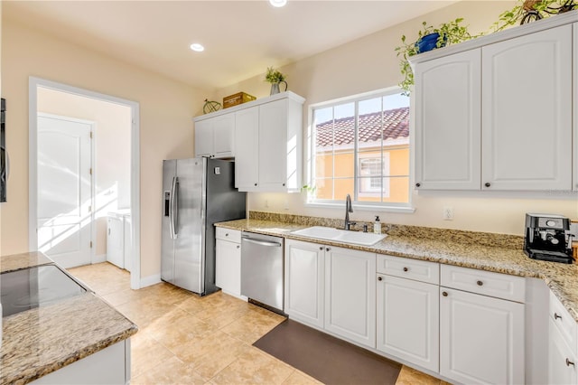 3145 Connemara Dr, Ormond Beach, FL 32174 - kitchen featuring stainless steel appliances, white cabinetry, washing machine and clothes dryer, light tile patterned floors, and light stone countertops
