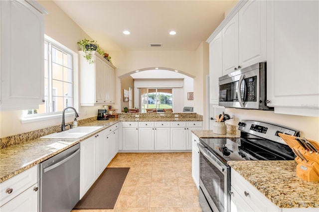 3145 Connemara Dr, Ormond Beach, FL 32174 - kitchen with stainless steel appliances, white cabinets, light tile patterned floors, light stone countertops, and recessed lighting