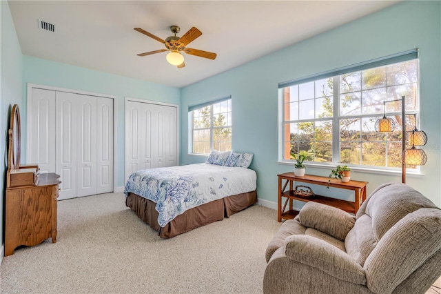 3145 Connemara Dr, Ormond Beach, FL 32174 - carpeted bedroom featuring two closets and a ceiling fan