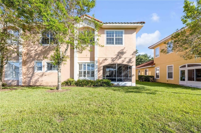 3145 Connemara Dr, Ormond Beach, FL 32174 - back of property with stucco siding, a lawn, a tile roof, and a sunroom