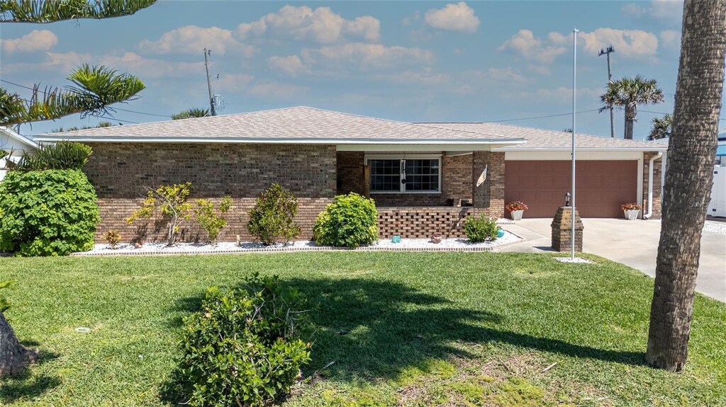 7 Kathy Dr, Ormond Beach, FL 32176 - ranch-style house with a garage, a front yard, brick siding, a shingled roof, and driveway