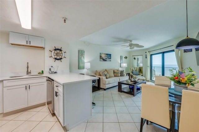 kitchen featuring a peninsula, white cabinetry, dishwasher, light countertops, and a sink