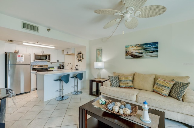 living room featuring light tile patterned flooring, a ceiling fan, and visible vents