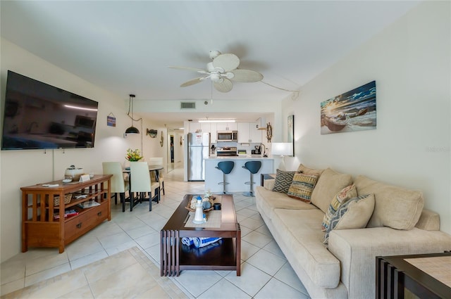 living area featuring light tile patterned floors, visible vents, and ceiling fan