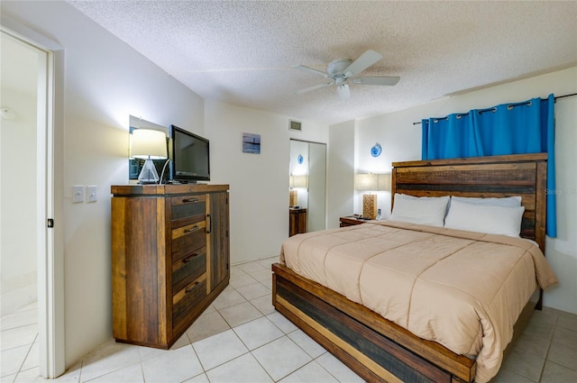 bedroom with visible vents, a ceiling fan, light tile patterned flooring, and a textured ceiling