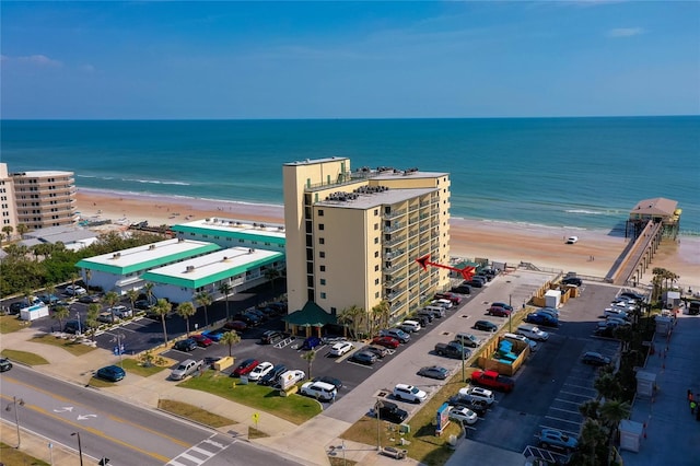 drone / aerial view with a water view and a beach view