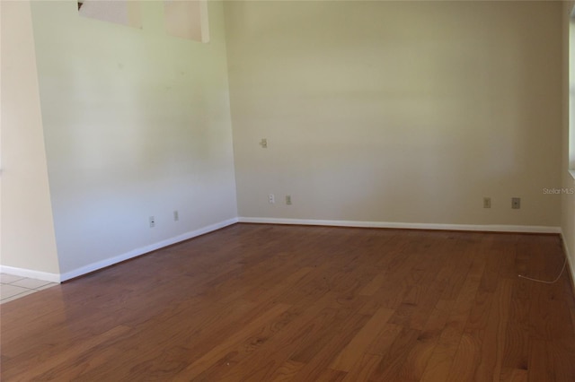 unfurnished room with wood finished floors and baseboards