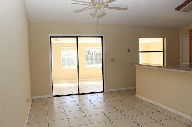 unfurnished room with light tile patterned floors, baseboards, and ceiling fan