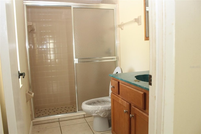 bathroom with tile patterned flooring, a stall shower, toilet, and vanity